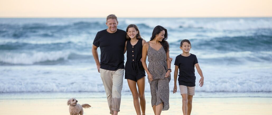 Familie am Strand mit kleinem Hund