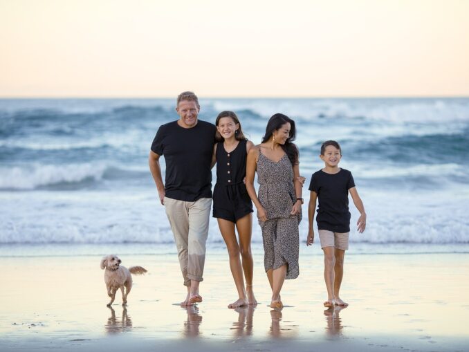 Familie am Strand mit kleinem Hund