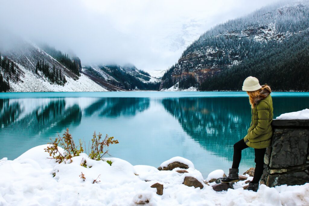 Frau am Wasser Schnee und Berge